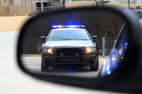 For all of us to get home safe - rear view mirror showing a police car with flashing lights