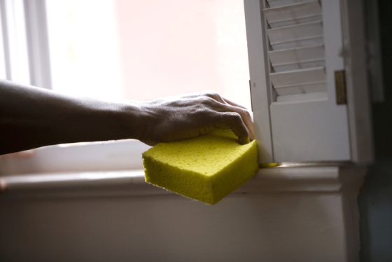 person cleaning window ledge