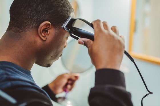 What To Include in Your Quarantine Routine - Man cutting hair in bathroom