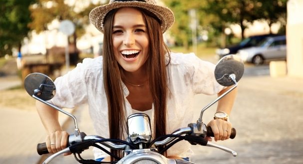 Tips to help your teen ride a motorcycle- A teen girl riding a motorcycle happily