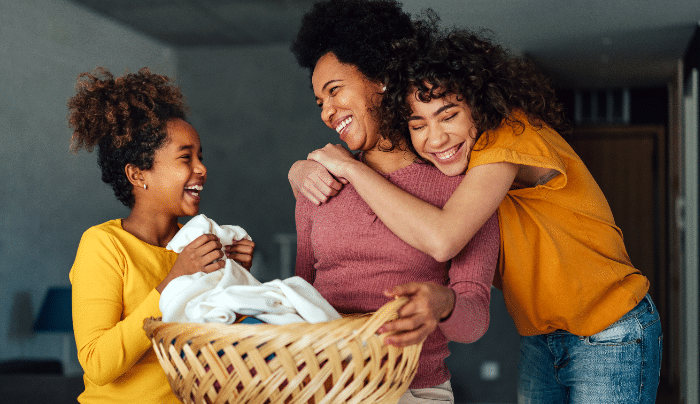 Balancing Household Responsibilities In A Blended Family-Teen girls doing laundry with their mom