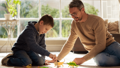 bonding with stepchildren -Stepdad and stepkid, playing with toys at house for plastic dinosaur