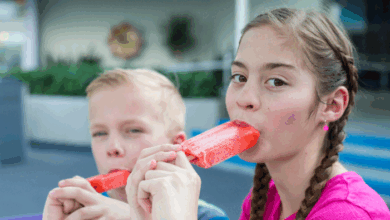 How to make the hot summer comfortable for kids-Two Children Eating Fruit Popsicles Outside on Summer Day