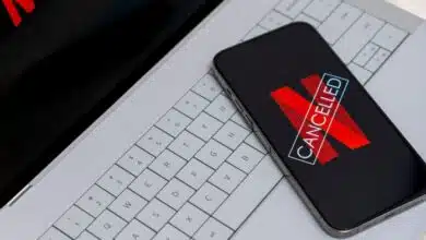 Smartphone displaying Netflix cancelled message on laptop keyboard with red logo.